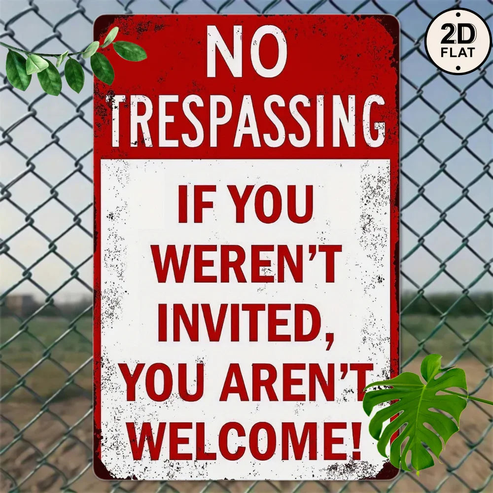 Vintage metal no trespassing sign with bold red text on a chain-link fence background