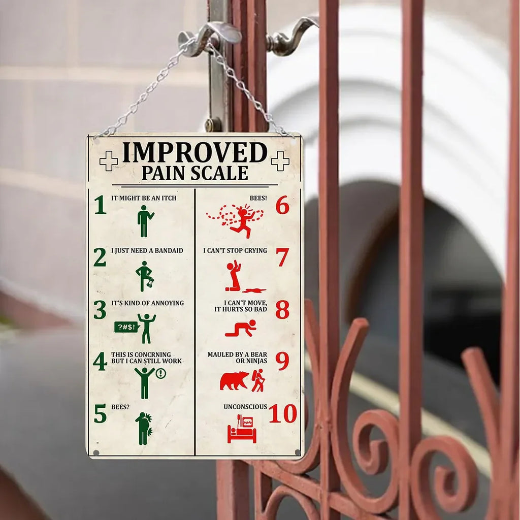 Vintage metal sign with a humorous improved pain scale chart hanging on a gate outdoors.