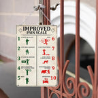 Vintage metal sign with a humorous improved pain scale chart hanging on a gate outdoors.