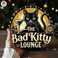 Vintage tin sign featuring black cat, cocktail, and bottles with 'The Bad Kitty Lounge' text.